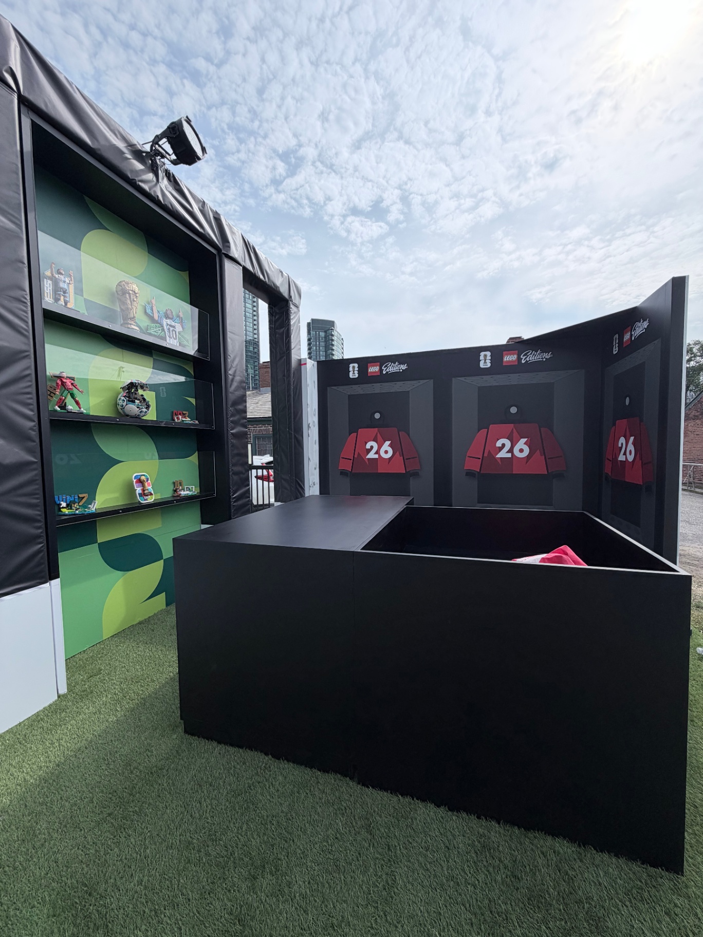 LEGO Editions locker-room moment with red number 26 jerseys and collectible LEGO sets on green display shelves