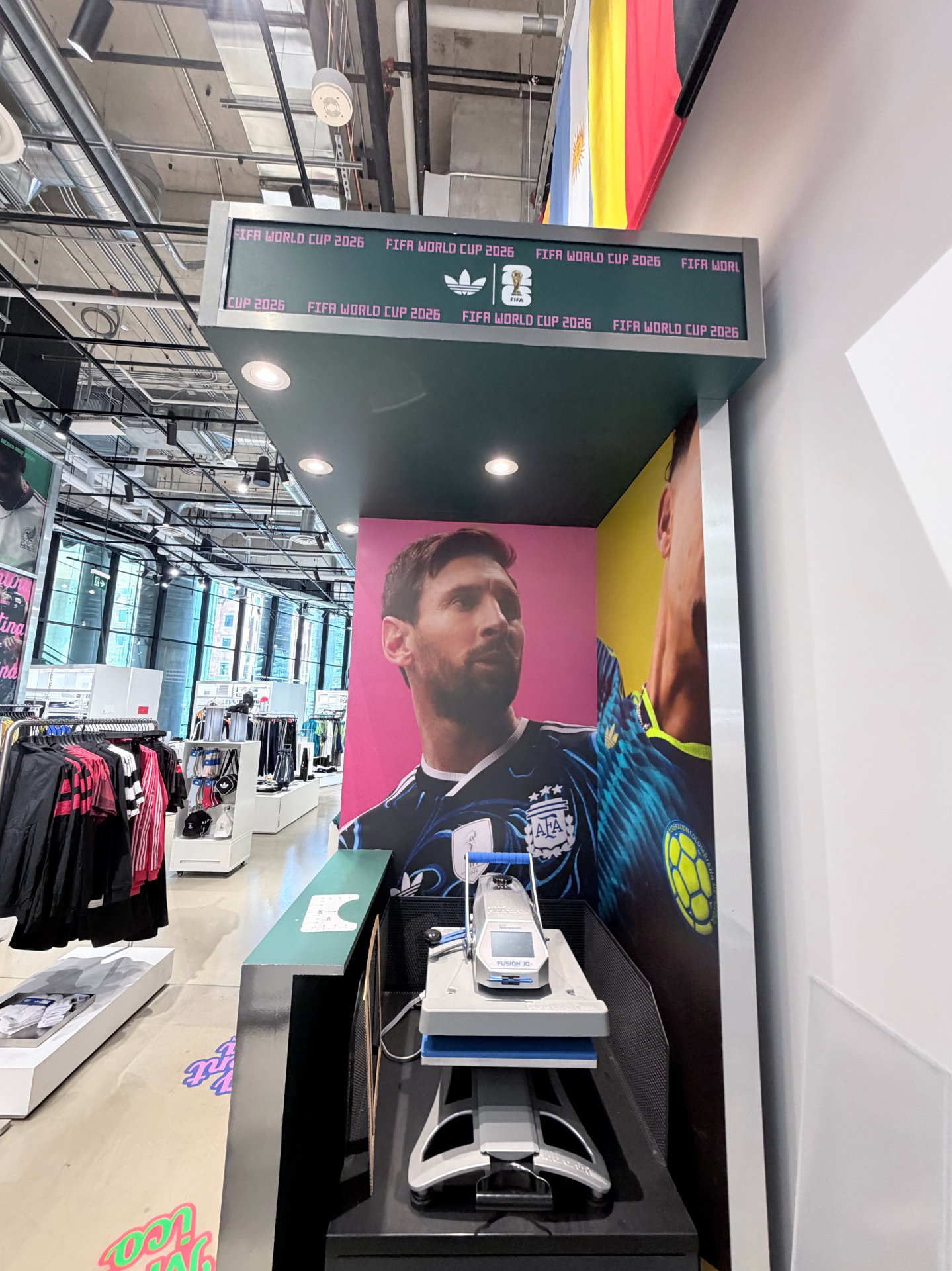 adidas FIFA World Cup 26 heat-press flocking station with FIFA WORLD CUP 2026 LED ticker overhead inside the adidas flagship at The Well