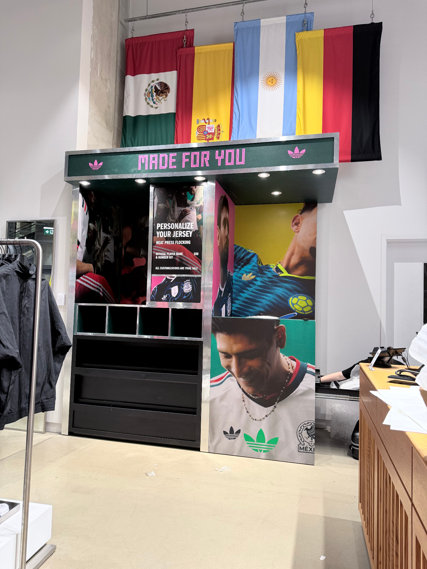 adidas FIFA World Cup 26 'Made For You' booth with hanging Mexico, Spain, Argentina, and Germany national-team flags above