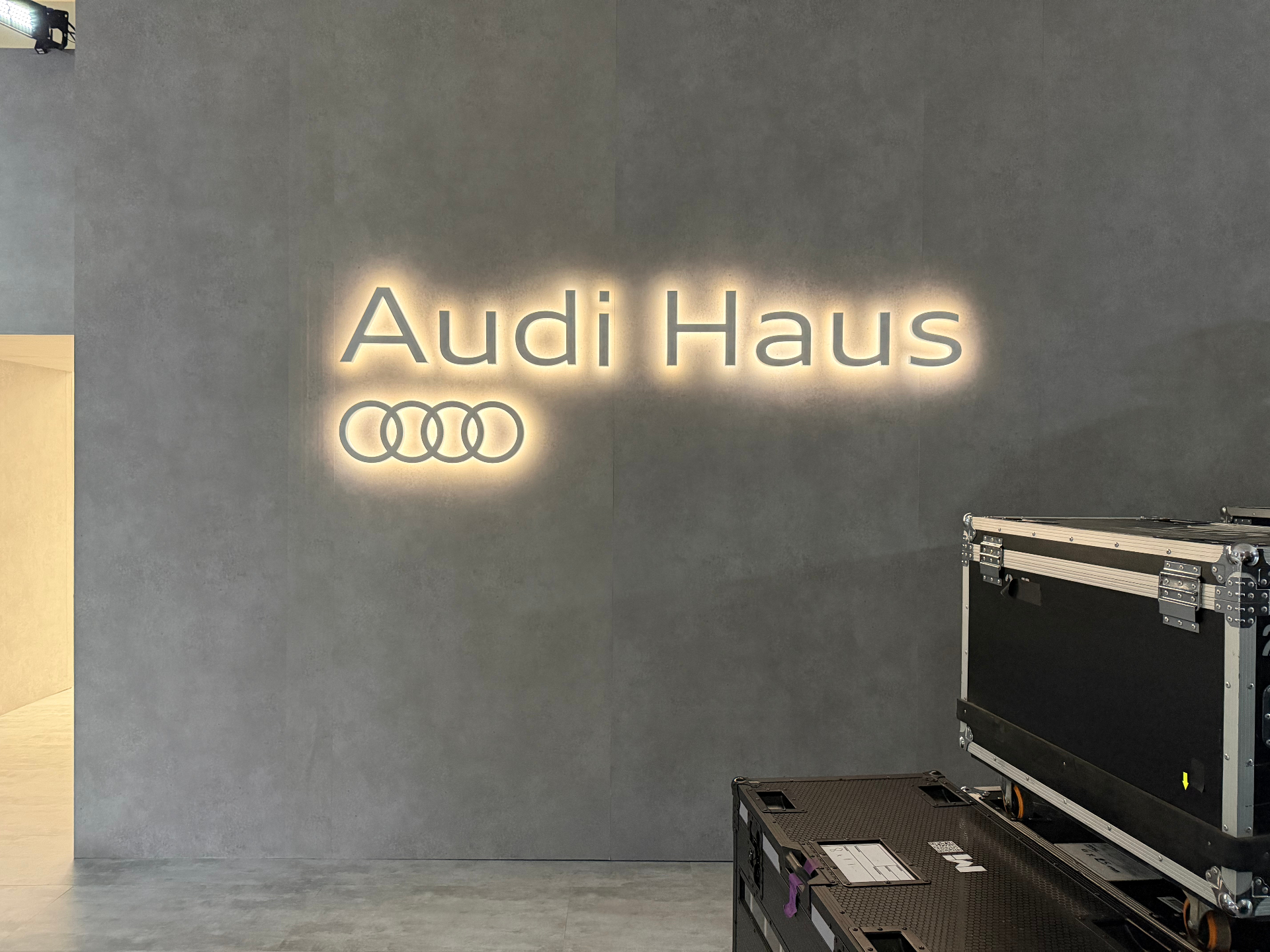 Backlit Audi Haus identity sign on concrete wall