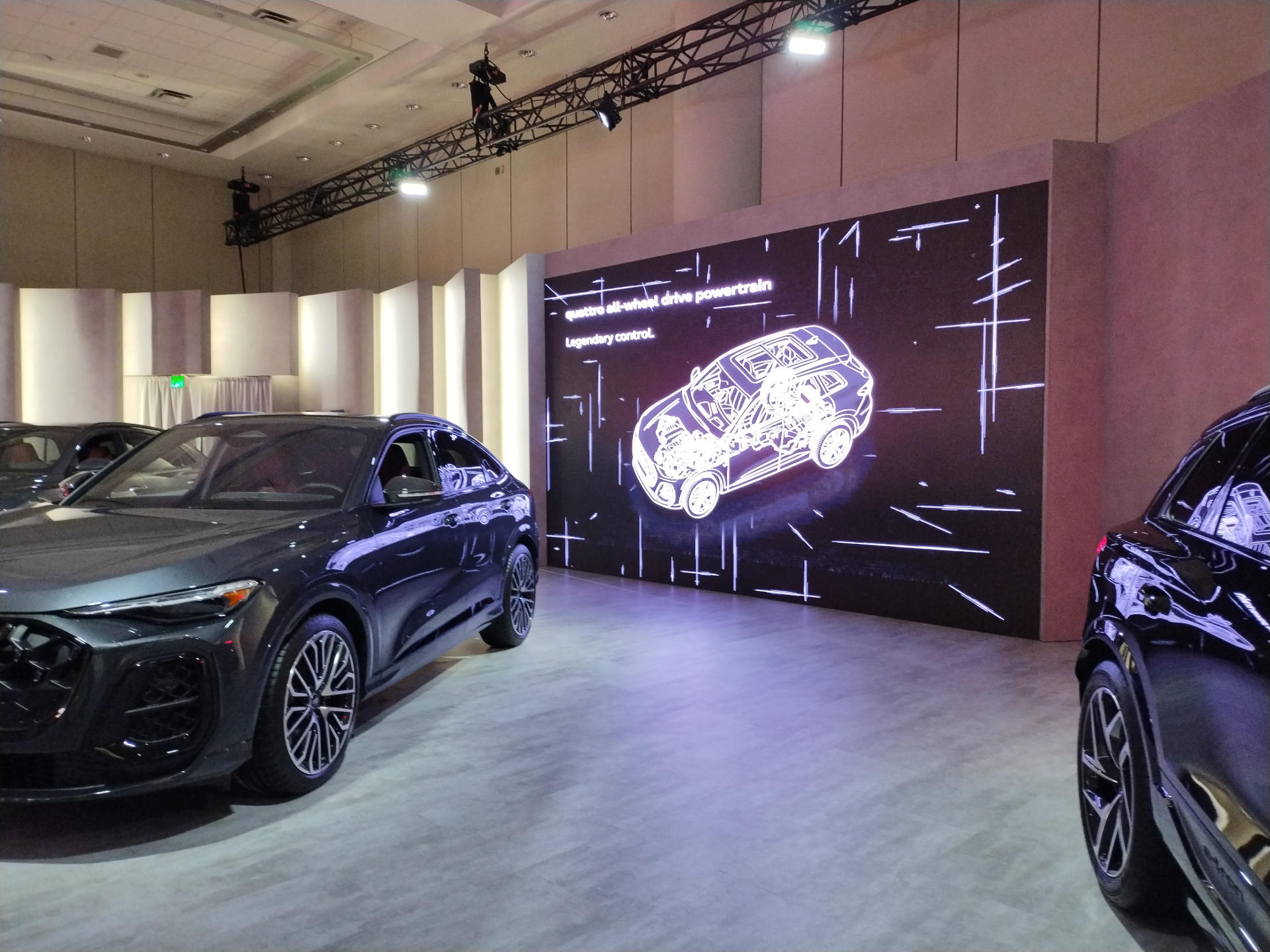 Audi vehicle display beside a large quattro all-wheel drive LED wall