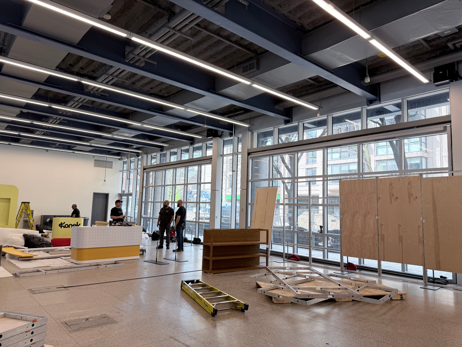 Interac activation during build-out with unfinished wall panels, counters, and open venue glazing