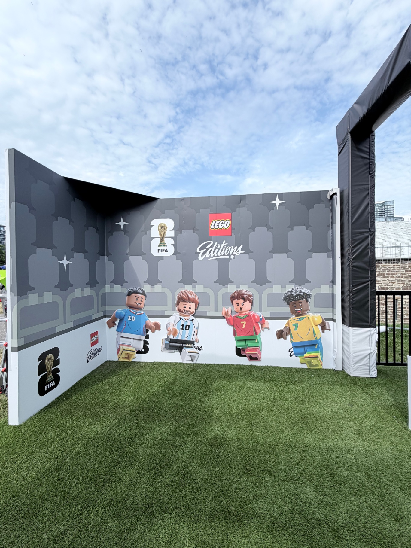 LEGO Editions x FIFA 26 player photo wall with four minifigure footballers on a turf floor